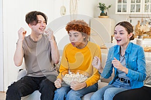 Group of friends watching sport match soccer football game on tv. Happy football fans celebrating victory at home