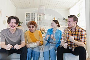 Group of friends watching sport match soccer football game on tv. Happy football fans celebrating victory at home