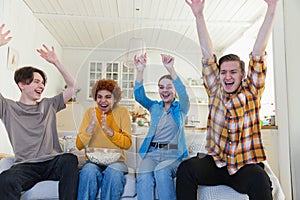 Group of friends watching sport match soccer football game on tv. Happy football fans celebrating victory at home