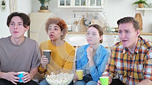 Group of friends watching sport match soccer football game on tv at home. Football fans disappointed missing goal