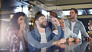 Group of friends watching sports program in bar, upset about losing game, defeat