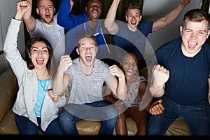 Group Of Friends Watching Television At Home Together