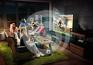 Group of friends watching TV, football match, sport together