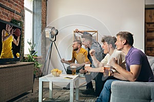 Group of friends watching TV, sport match together. Concept of friendship, leisure activity, emotions