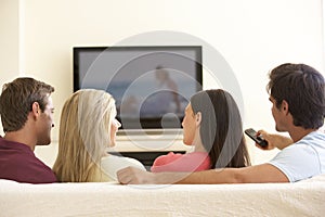 Group Of Friends Watching Widescreen TV At Home