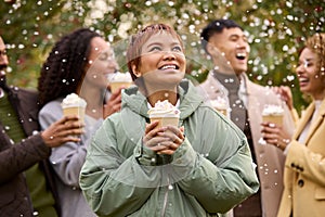 Group Of Friends Wearing Coats Standing Outside In Snow Holding Takeaway Hot Chocolate Drinks