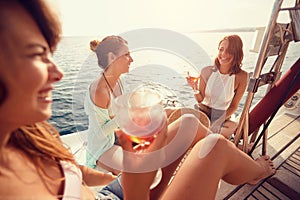 Group of friendâ€™s girl having party on sailing boat and drinking wine