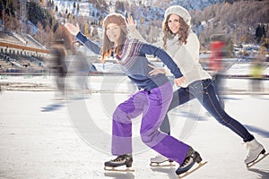 Group funny teenagers ice skating outdoor at ice rink