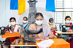 group of garments workers in medical face mask buys working at garments on sawing to protect from coronavirus or covid