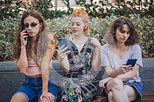 Group of girlfriends using smartphones. Emotional isolation and technology depresion