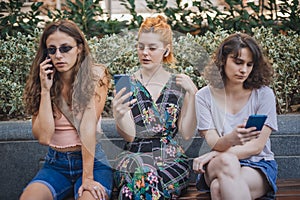 Group of girlfriends using smartphones. Emotional isolation and technology depresion photo