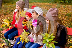 Group of girls in autumn park on the brench