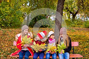 Group of girls in autumn park on the brench photo