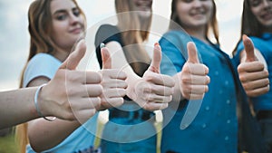 A group of girls girlfriends show thumbs up.