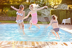 Group Of Girls Jumping Into Outdoor Swimming Pool