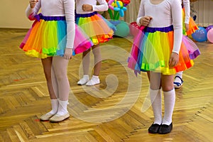 A group of girls in kindergarten performs in bright skirts