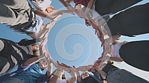 A group of girls makes a circle from their palms.