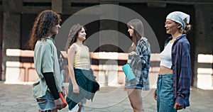 A group of girls meet in neighborhood garages in the city to do a dueling dance. The teens hold portable music speakers