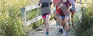 Group of girls running on the boardwalk at the beach