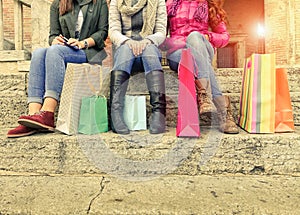 Group girls sitting and chatting after shopping in city