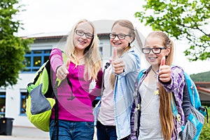 Group of girls standing in front of school