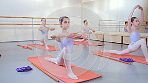 Group of girls study in a ballet school, practicing gymnastics exercises.