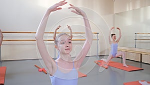 Group of girls study in a ballet school, practicing gymnastics exercises.