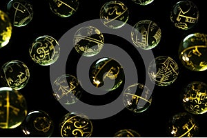 A group of glass balls decorated with gold symbols soaring in the air against a black background.