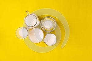 Group glass of milk on yellow background with copy space