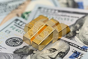 group of gold bar lie on 100 US dollar bills background