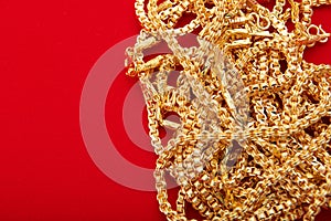 Group of gold necklaces on red background