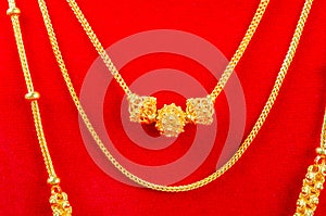 Group of the gold necklaces on red color background