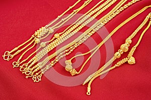 The Group of gold necklaces on red velvet fabric