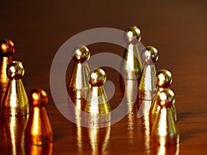 A group of Golden and yellow tokens placed randomly over a wooden table horizontal