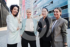 Group of good looking business women standing at workplace and posing for the portrait with successful expression