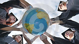 A group of graduates hug a globe of peace. The concept of preserving peace.
