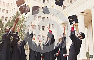 A group of graduates throwing graduation caps in the air