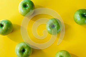Group of green apples on yellow background