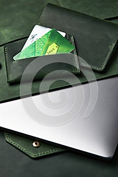 Group of green leather goods handmade on a wooden table. Top view, close-up.