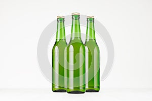 Group green longneck beer bottles 500ml, mock up. Template for advertising, design, branding identity on white wood table.