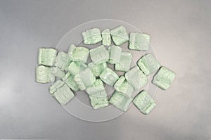 Group of green packing peanuts on a metal surface
