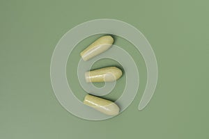 Group of green rectal suppositories for anal or vaginal use on  background. Pills for alternative medicine, lowering