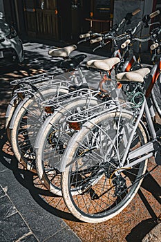 Group of grey bikes for rent outside a bicycle rental shop