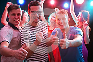 Group of guys dancing in the night club photo