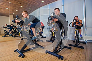 Group of gym people on machines, cycling In Class