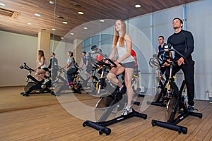 Group of gym people on machines, cycling In Class