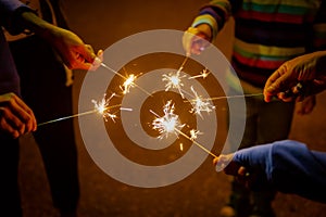 Group hands holding Burning sparking stick starlight fireworks pyrotechnic warm