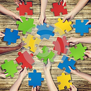 Group of Hands Holding Jigsaw Puzzle