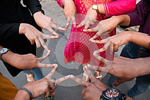 Group of hands showing peace hand sign, connecting fingers like star, down view