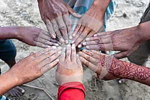 A group of hands touch each other like a seance. The hands of the children together